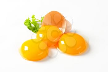 Three fresh egg yolks and empty eggshell