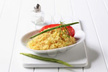 Side dish of couscous garnished with string beans
