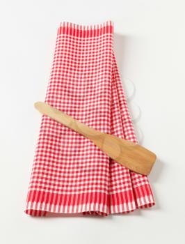 Red and white tea towel and wooden spatula