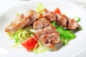 Grilled pork tenderloin on nest of salad greens