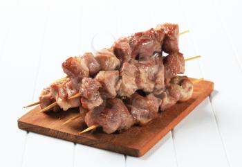 Grilled pork kebabs on cutting board
