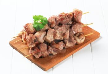Grilled pork kebabs on cutting board