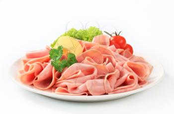 Thinly sliced ham arranged on a plate