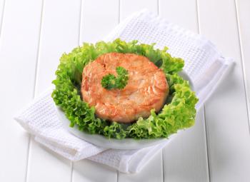Pan fried salmon patty served on lettuce