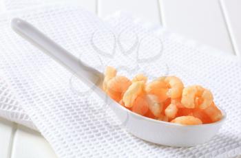 Cooked shrimps on a porcelain spoon