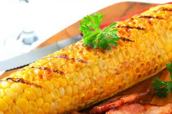 Grilled corn and fried pieces of salt pork