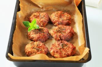 Vegetable patties on baking parchment paper in baking pan