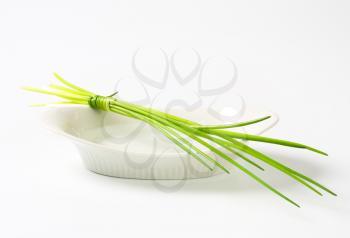Bunch of fresh chives on porcelain dish