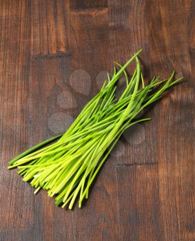 Fresh chives leaves on wooden background