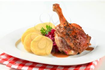 Dish of roast duck leg with potato dumplings and red cabbage