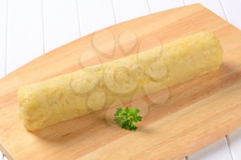 Long roll-shaped potato dumpling ready to be cut into slices