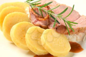 Dish of pork meat with potato dumplings and white cabbage