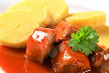 Pork meat in tomato sauce served with potato dumplings