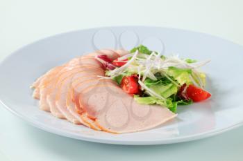 Thinly sliced turkey breast garnished with fresh salad