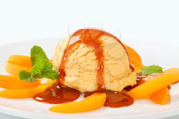 Ice cream with fresh apricot slices and caramel sauce
