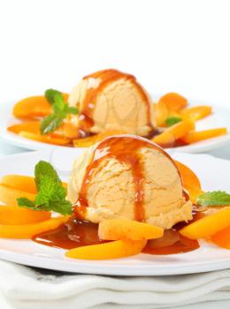 Ice cream with fresh apricot slices and caramel sauce