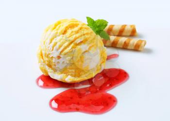 Scoop of mango lemon ice cream with raspberry sauce