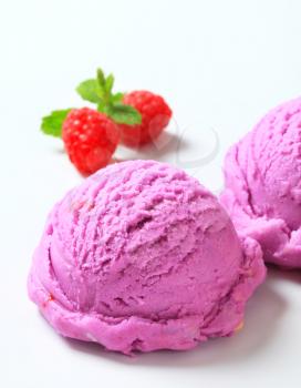 Scoops of purple ice cream  and fresh raspberries