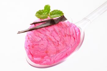 Scoop of pink ice cream on a plastic spoon