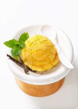 Scoop of yellow ice cream in a modern dessert dish