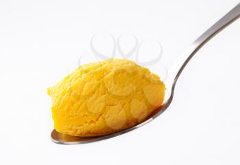 Yellow ice cream on a spoon