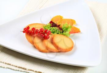 Slices of smoked cheese garnished with fruit