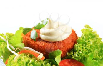 Green salad with fried breaded cheese and mayonnaise