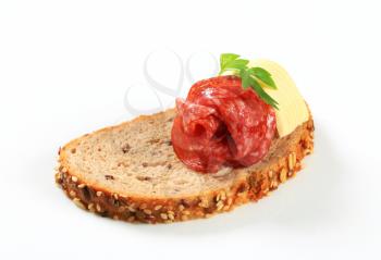 Slice of bread with butter and salami