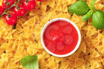 Uncooked bow tie pasta and tomato puree