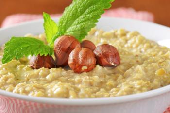 Bowl of white oats porridge with hazelnuts