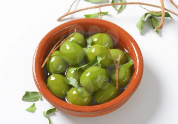 Bowl of green olives in oil