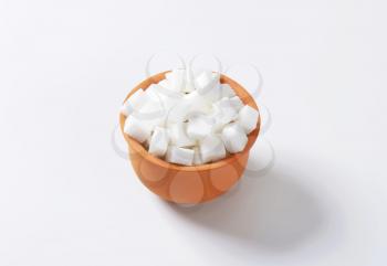 White sugar cubes in terracotta dish