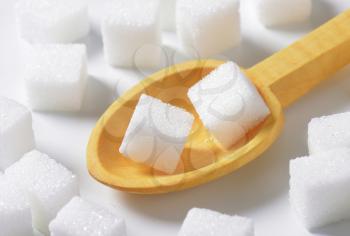 White sugar cubes and small wooden spoon