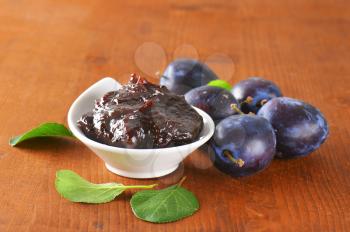 Bowl of homemade plum jam and fresh plums