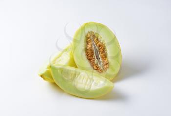 Yellow melon half and slices on white background
