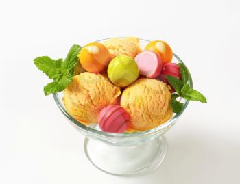 Fruit-flavored ice cream and white chocolate bonbons in a coupe