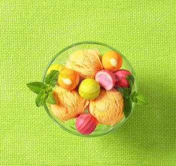 Fruit-flavored ice cream and white chocolate bonbons in a coupe