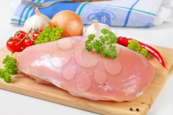 Raw turkey breast and vegetables on cutting board