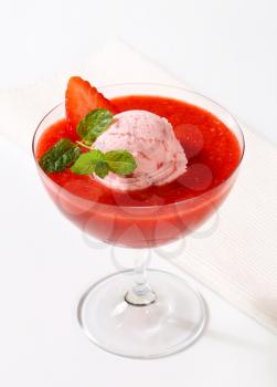 Ice cream with strawberry puree in stemmed glass