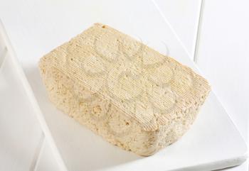 Block of homemade tofu on cutting board