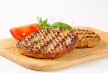Grilled patties on cutting board