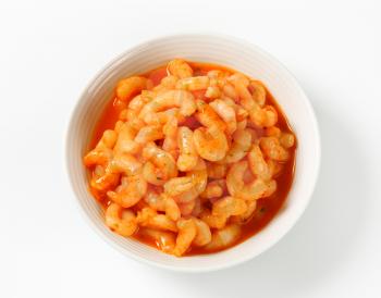 Bowl of cooked peeled shrimps with spicy sauce