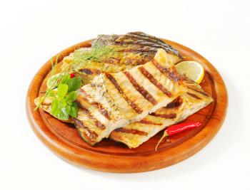 Grilled carp fillets on cutting board