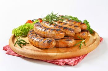 Grilled bratwursts on cutting board