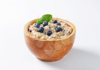 Bowl of whole grain oat porridge with blueberries
