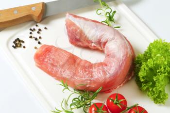 Raw pork tenderloin on cutting board