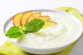 Bowl of smooth milk pudding with apple slices