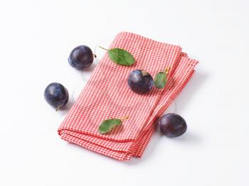 Fresh ripe plums and red table cloth