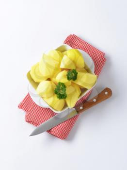 Raw peeled potatoes in ceramic dish
