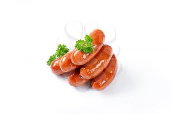 stack of pan fried sausages on white background